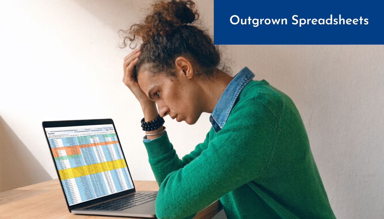 A person looking stressed while working on a complicated spreadsheet on a laptop computer screen.