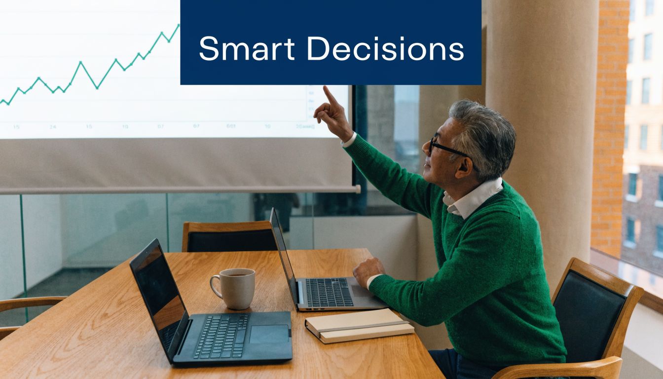 A professional man in a green sweater pointing at a financial growth chart on a screen
